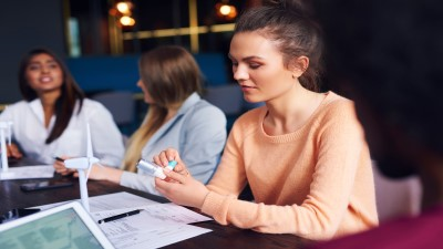 Individual holding up inhaler in a meeting