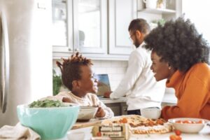 mother and child smiling at each other over kitchen island covered with food