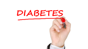 photo of a hand writing the word diabetes