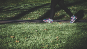 photo of the feet of a person in tennis shoes walking outside