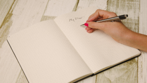 photo of a notebook with the words my plan and a hand with a pen