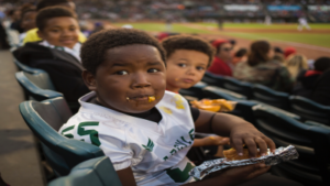 child eating junk food at sports event