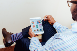 man with funky socks looks at data on tablet