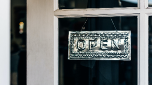 photo of a silver metal embossed open sign hanging in a window